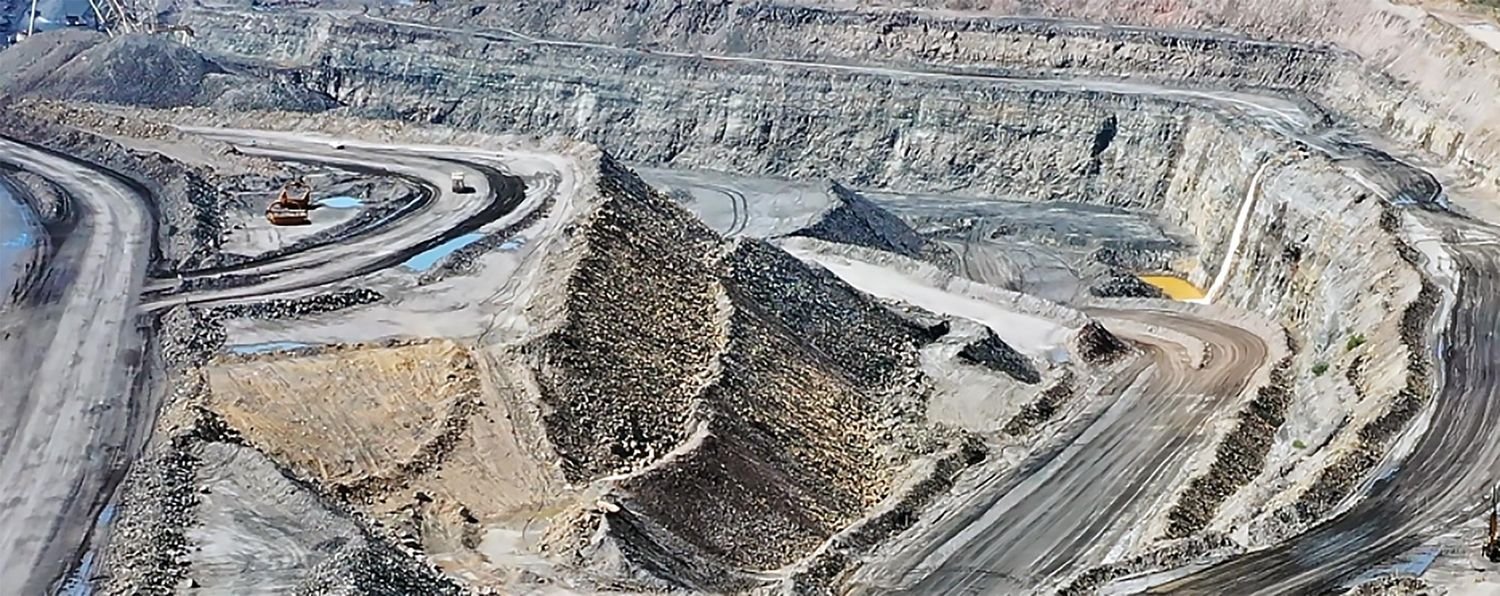 The terraced walls of the Collinsville open cut coal mine, with haul roads cut into the rock and machinery visible at the upper levels.