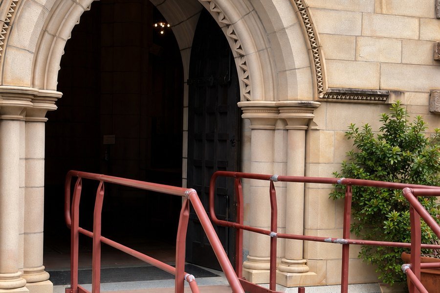 An arched sandstone entrance to St John's Cathedral, with ramp access.